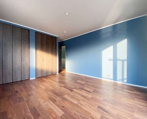 施工事例：木目調が映えるくすみブルー系のクールな内装の洋室