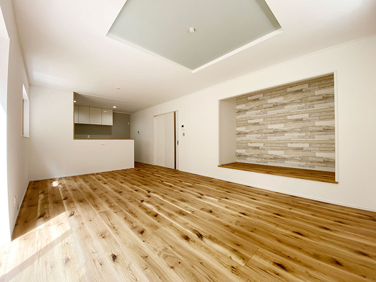 小菅ヶ谷3丁目 モデルハウス：落ち着いた色合いのアクセントウォールと床材が高級感を醸し出すLDK