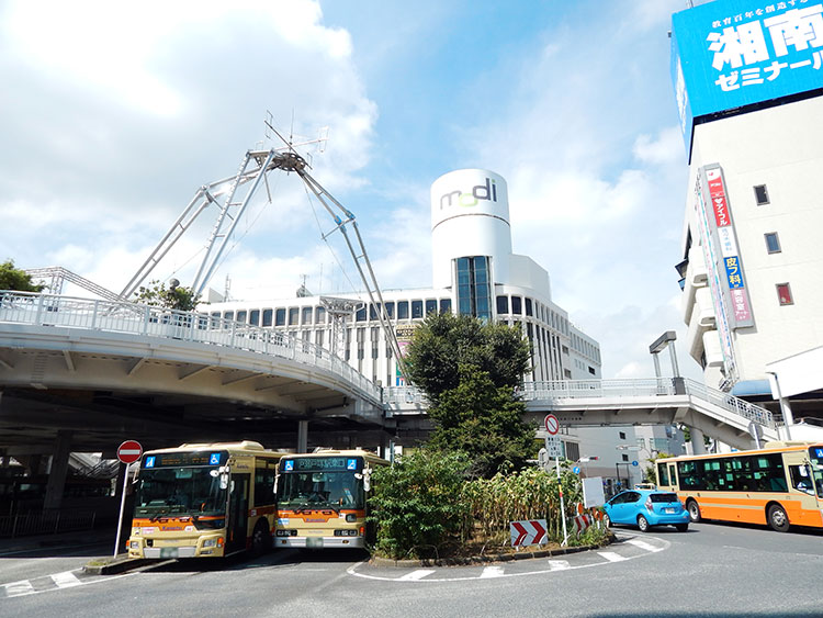 JR戸塚駅東口駅前のバスターミナルで待機している神奈中バス。駅前にはショッピングモール「戸塚モディ」が見えます。