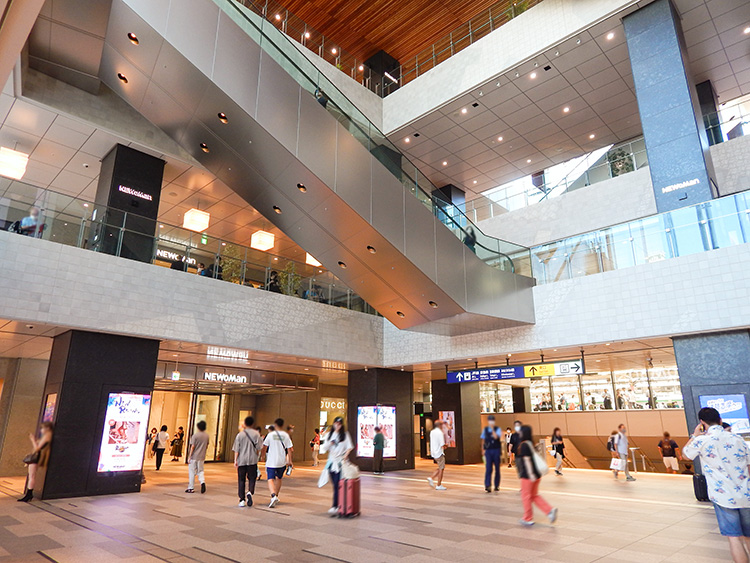 多くの人が行き交うJR横浜駅西口。駅ビルニュウマンの1F入り口とガラス越しにホームが見える。