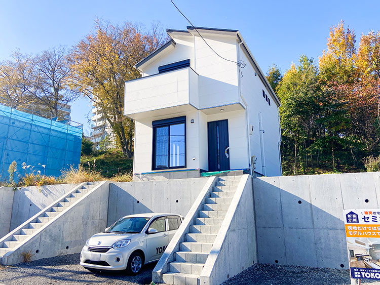 青空に映える白いお家。高基礎のデザインでお家が一段高くなっているので、陽当たりも風通りもバツグンです。手前には広々としたカースペースがあります。